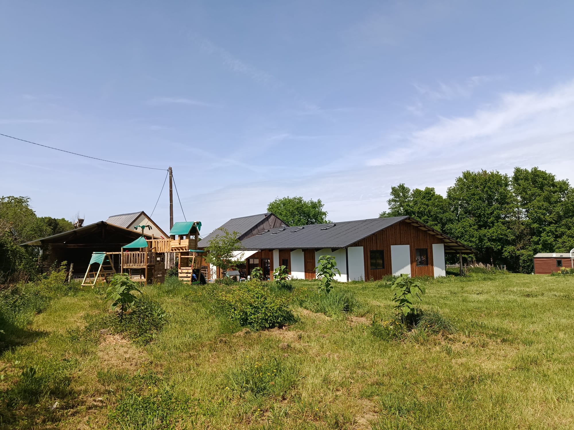Overzicht van het domein na renovatie met kinderspeelplek en moestuin