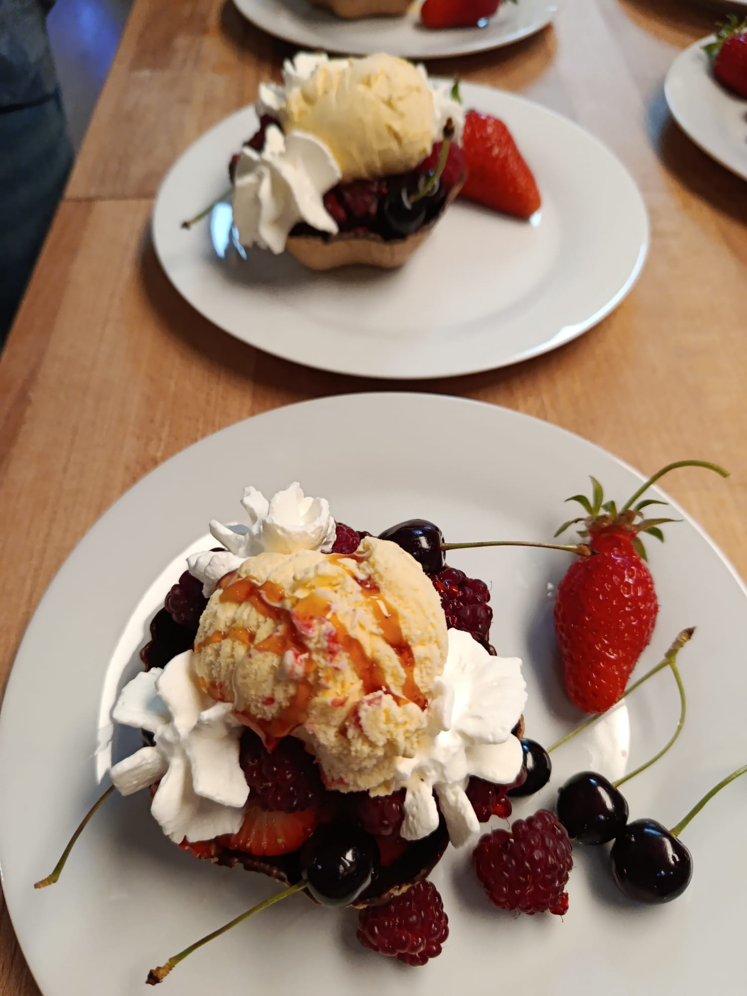 Dessert met rood fruit aan tafel geserveerd